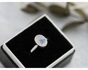 Sterling silver ring with oval faceted moonstone set in a bezel setting with simple silver ring band. 